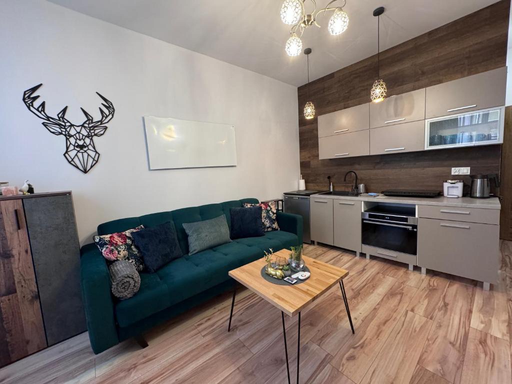 a living room with a green couch and a table at Apartament w centrum Jeleniej Góry przy ulicy Długiej in Jelenia Góra