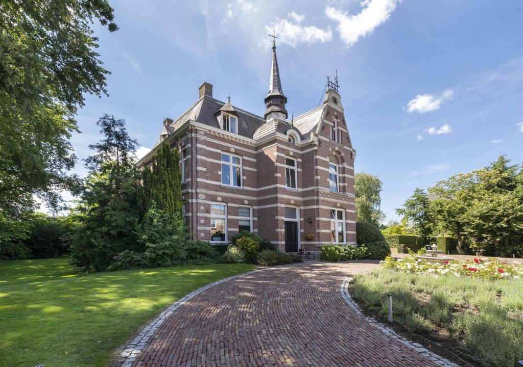 a large brick building with a steeple on top at B&B Villa van Voss in Etten-Leur
