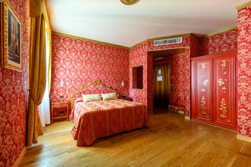 a bedroom with red wallpaper and a bed in it at Residenza Ca' San Marco in Venice