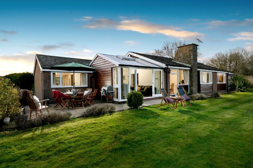 una casa con un patio con sillas y una mesa en Pendennis at Eaton Manor, en Church Stretton