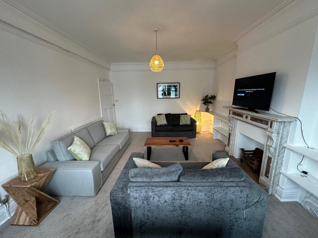 a living room with a couch and a fireplace at Ashbrook Stert St 5 bedroom property in Abingdon