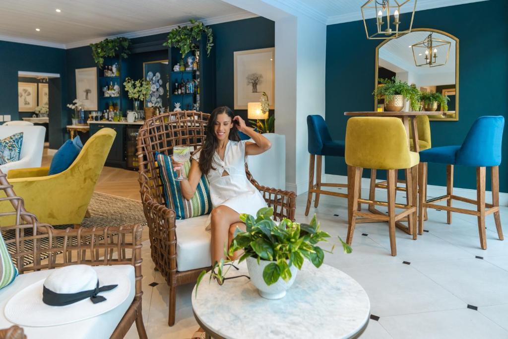 a woman sitting in a chair in a living room at Last Word Franschhoek in Franschhoek