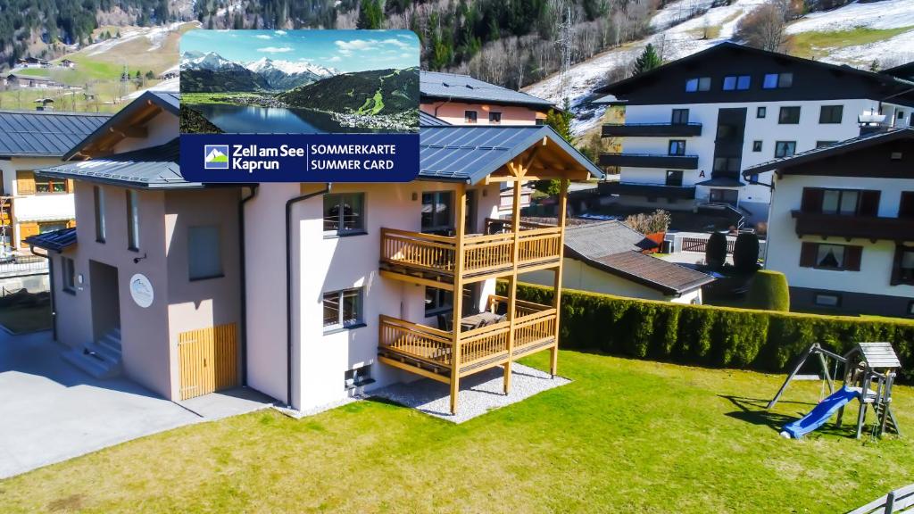 a house with a balcony with a playground at Tauern Relax Lodges by we rent, SUMMERCARD INCLUDED in Kaprun