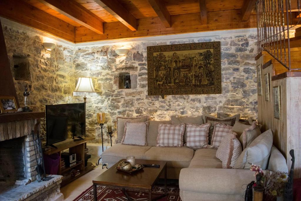 sala de estar con sofá y TV en Kleitor Stone Villa-Peloponnese Getaway en Klitoria