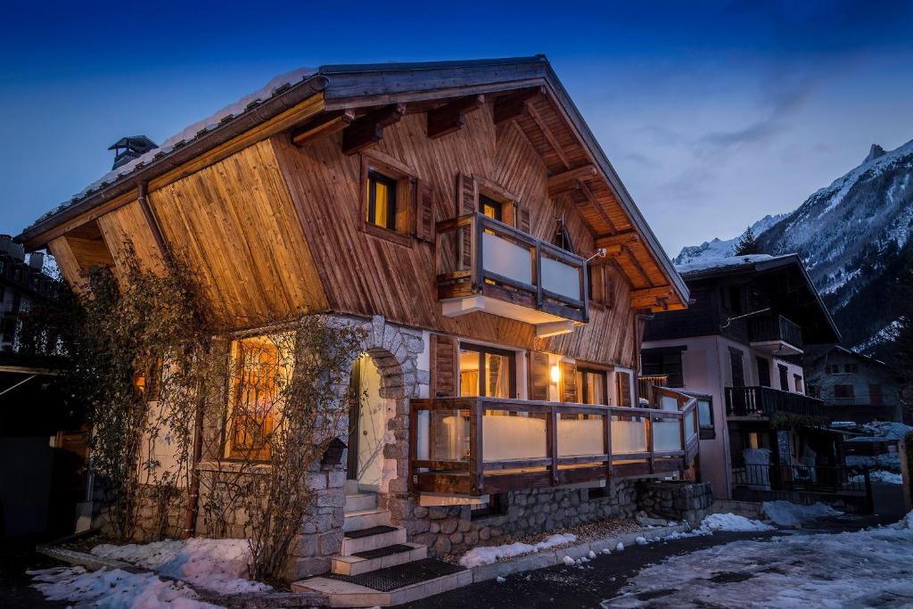 a large wooden house with a balcony in the snow at Chalet Grand Cru in Chamonix-Mont-Blanc