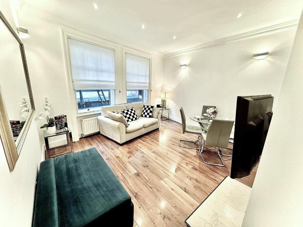 a living room with a couch and a table at Alluring 2-Bed, 2-Bath Flat on High Street Kensington, Near Kensington Palace in London