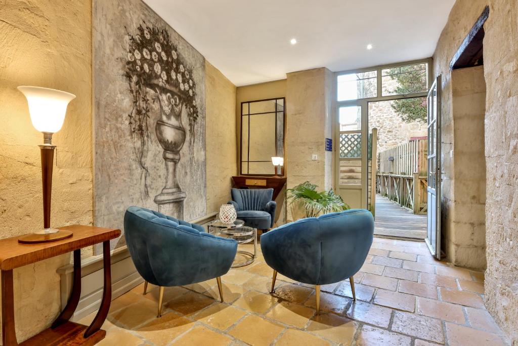 サルラ・ラ・カネダにあるLa Villa des Consuls - Gîte de tourisme de charmeのリビングルーム(青い椅子2脚、テーブル付)