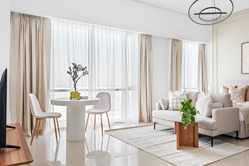 Silkhaus Elegant Studio Near Silicon Central Mall في دبي: غرفة معيشة مع أريكة وطاولة