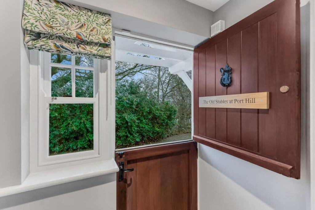 a hallway with a window and a door with a sign at The Old Stables at Port Hill in Medbourne