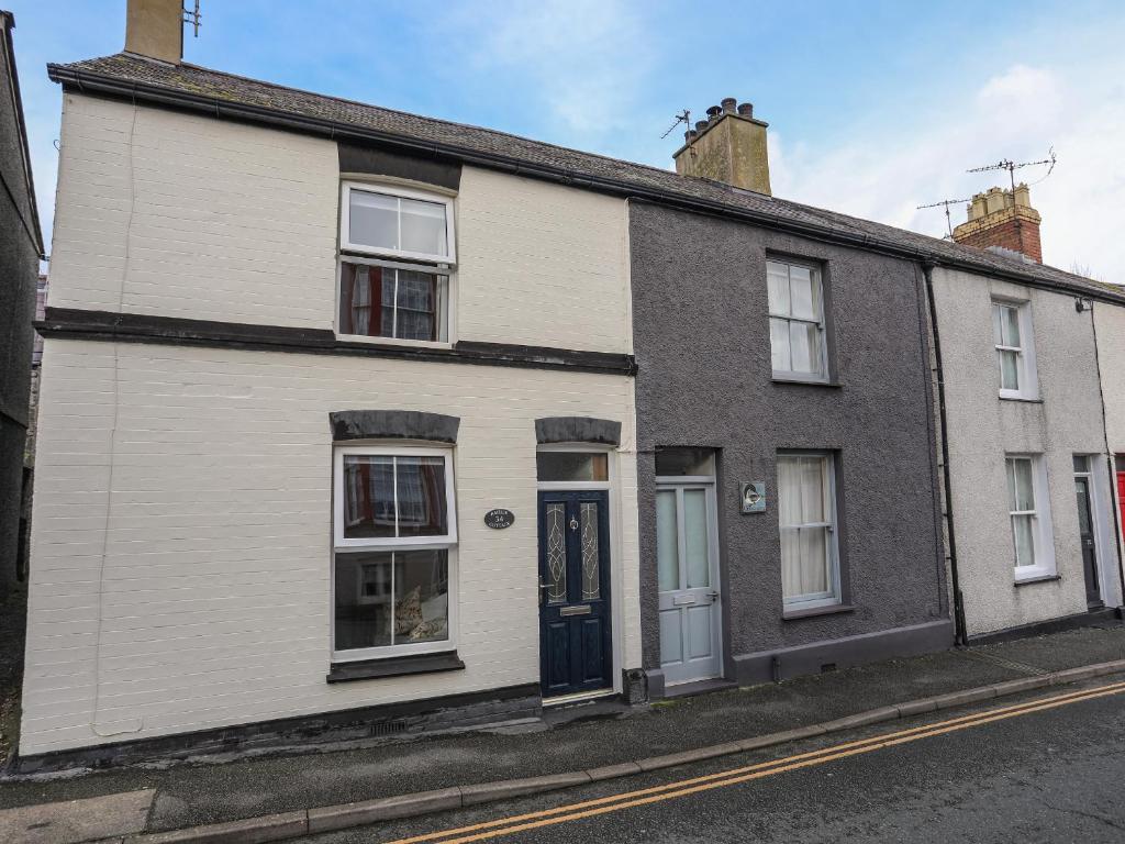 a white and black house on a street at Amelie Cottage in Beaumaris
