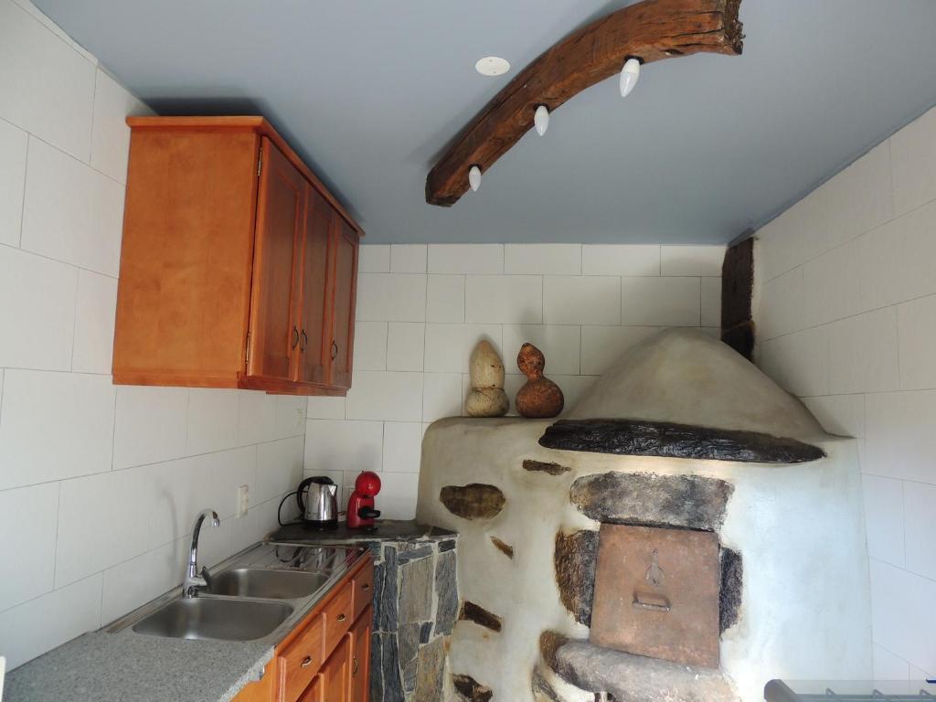a kitchen with an old oven in the corner at Casa do Forno in Mondim de Basto