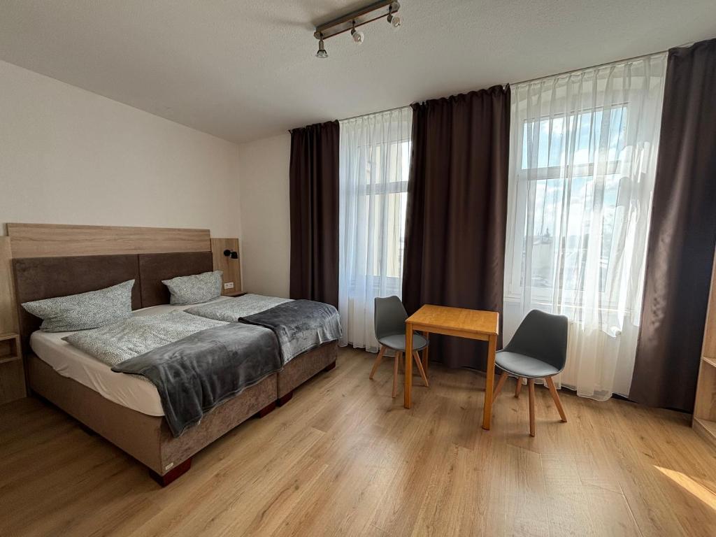 Schlafzimmer mit einem Bett, einem Tisch und Stühlen in der Unterkunft Deutscher Hof in Plauen