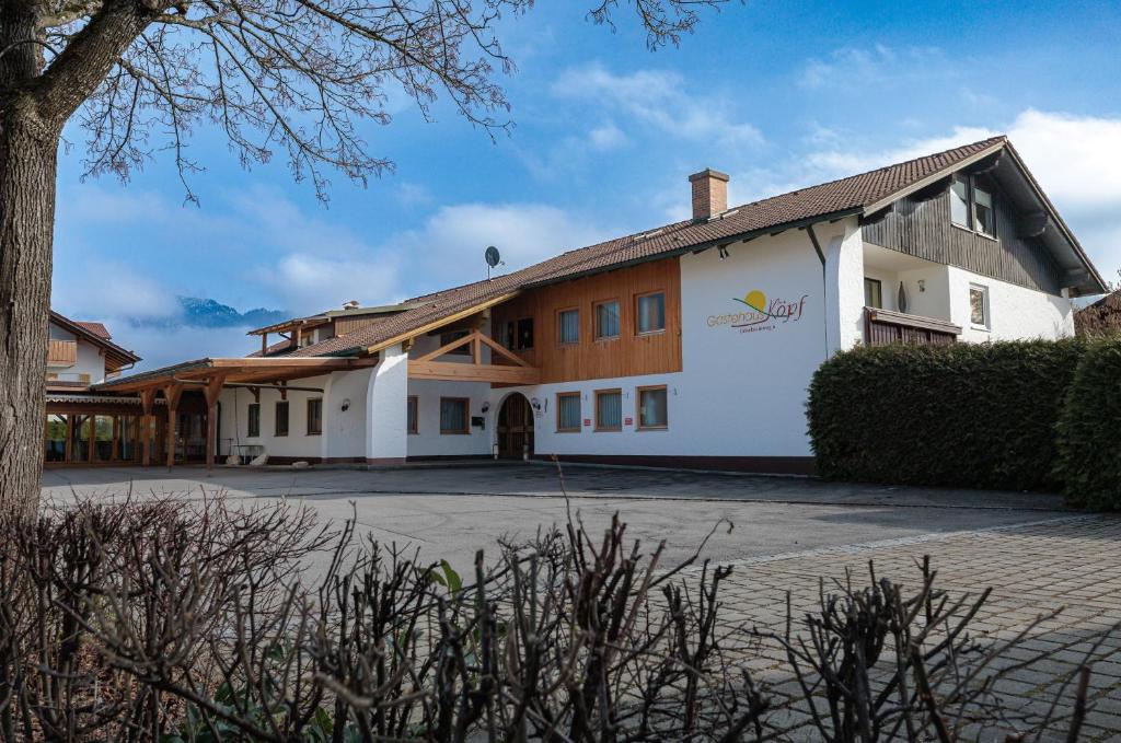 ein großes weißes Gebäude mit einem Dach in der Unterkunft Gästehaus Köpf in Füssen