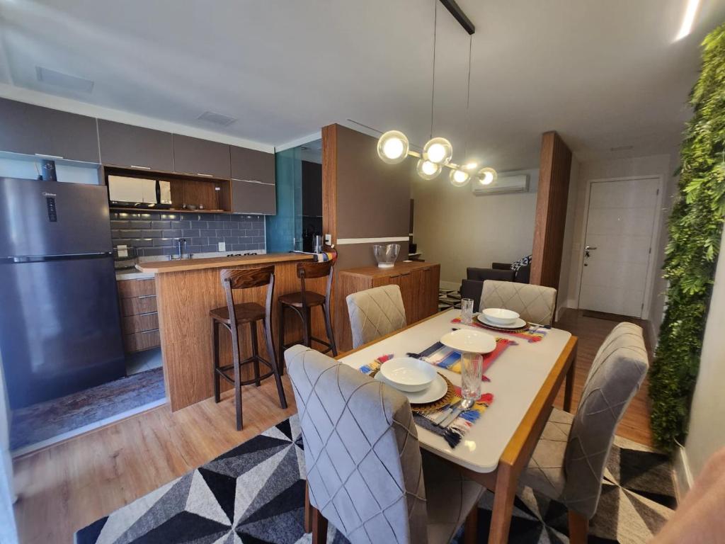 Hotel Flat na Praia da Barra da Tijuca, a kitchen and dining room with a table and chairs at Flat na Praia da Barra da Tijuca in Rio de Janeiro