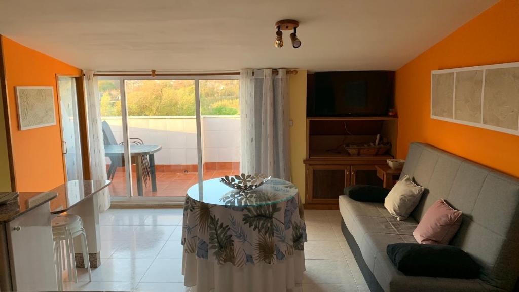 a living room with a couch and a table at Precioso ático en Playa América a 200 metros de la playa in Nigrán