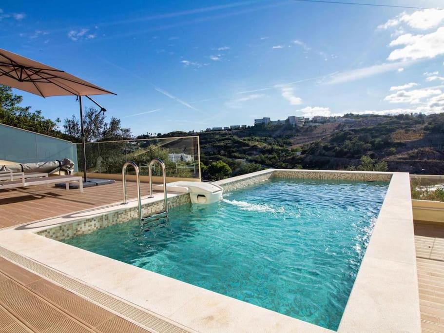 een zwembad in het midden van een huis bij Sea La Vie House - Privat Pool & Luxurious & Top View & Albufeira in Albufeira