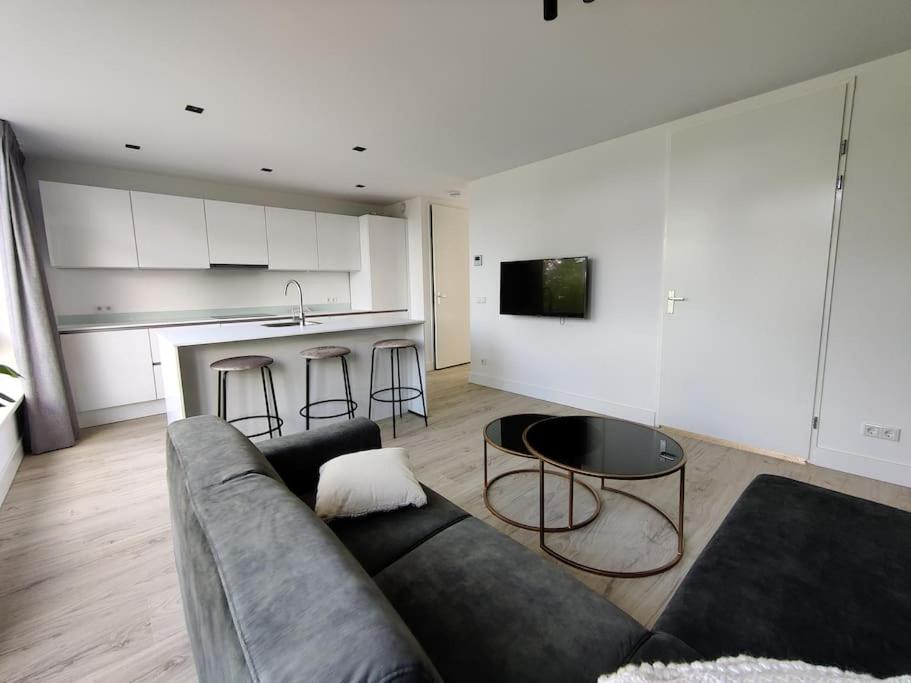 uma sala de estar com um sofá e uma mesa em K50173 Modern apartment near the center em Eindhoven