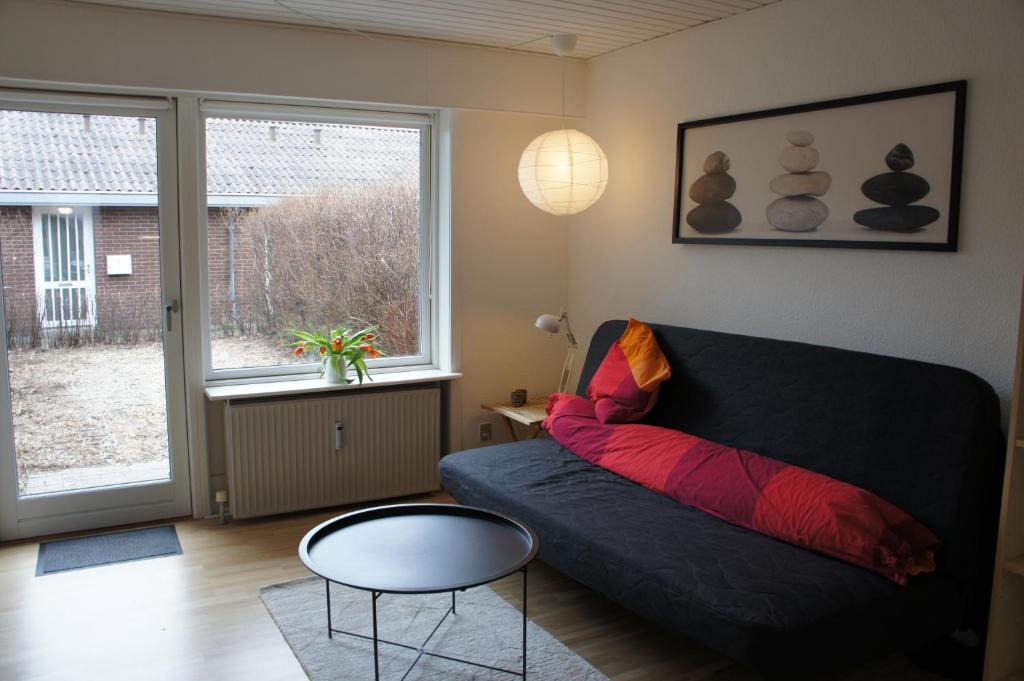 een woonkamer met een bank, een tafel en een raam bij (id110) Grønlandsparken 56. G in Esbjerg