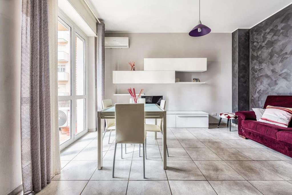 uma sala de jantar com uma mesa e um sofá vermelho em green oasis in milan - luxury appartment free wifi - Policlinico San Donato em San Donato Milanese