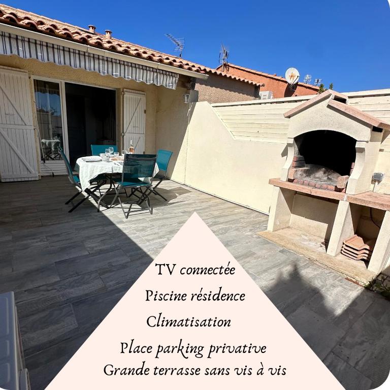 une terrasse avec une table et une cheminée dans une maison dans l'établissement La Discrète toute équipée avec piscine, à Gruissan