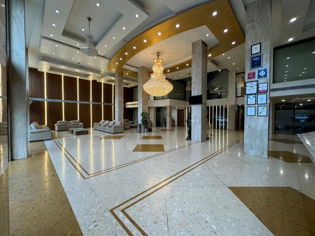 eine Lobby mit einem Kronleuchter in einem Gebäude in der Unterkunft Hotel The Evergrand Palace in Rajkot