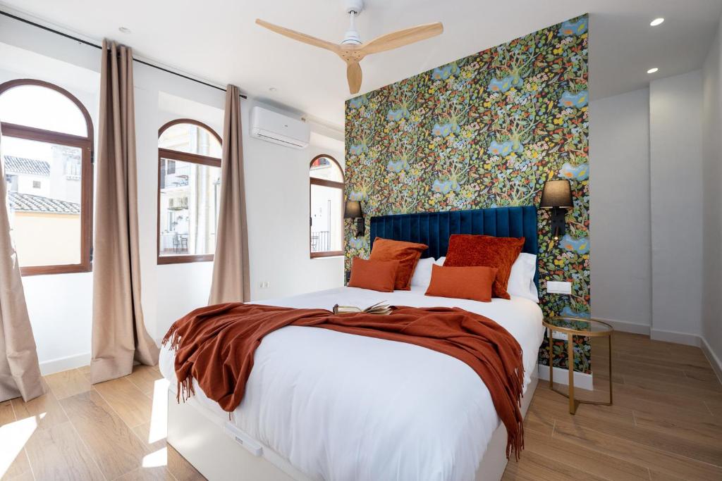 a bedroom with a large bed with a colorful wall at Villa Fortuny Unique Home in Granada