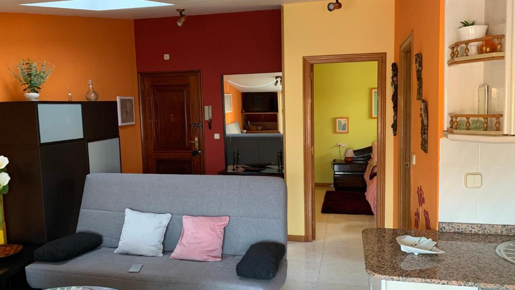 a living room with a gray couch with pink pillows at Precioso ático en Playa América a 200 metros de la playa in Nigrán