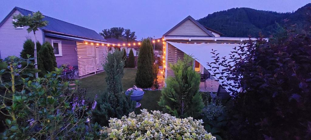 a house with lights in a garden at night at Tiny House Olivia in Liptovský Hrádok