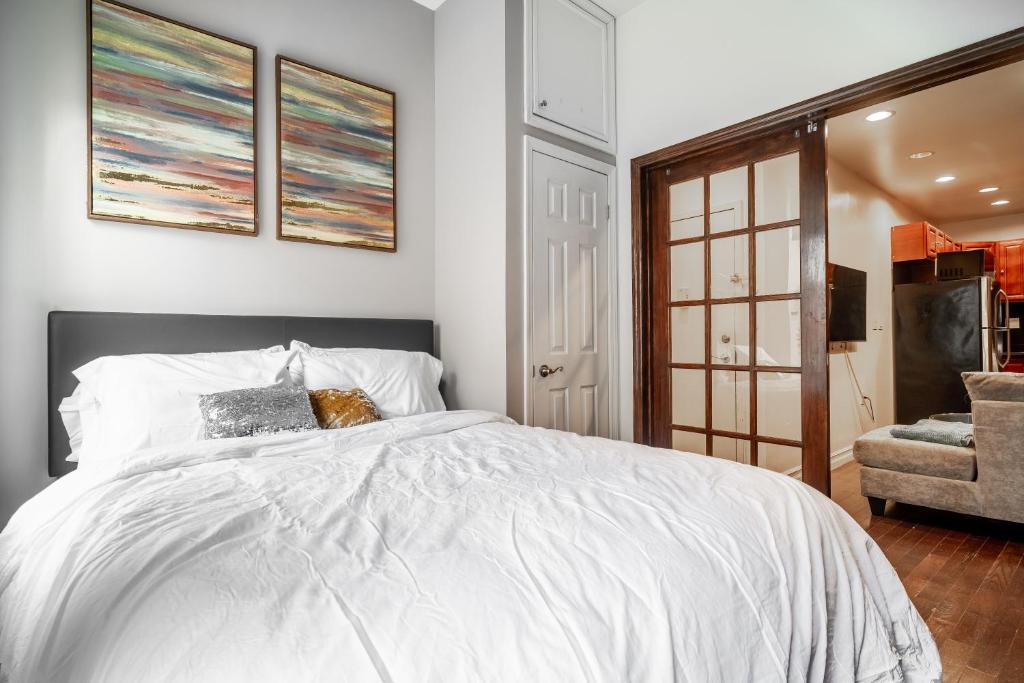 een slaapkamer met een wit bed en een stoel bij The Nest- 1 bedroom 1 bath convenient and cozy apartment in Brooklyn