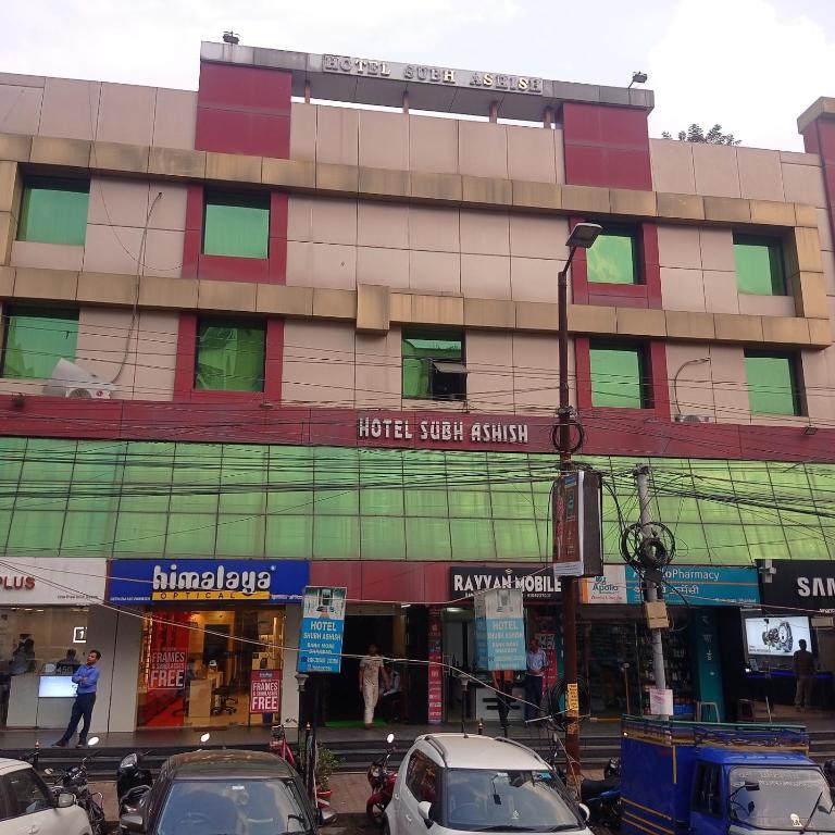 a building with cars parked in front of it at Hotel Shubh Ashish Near Bank More in Dhanbād