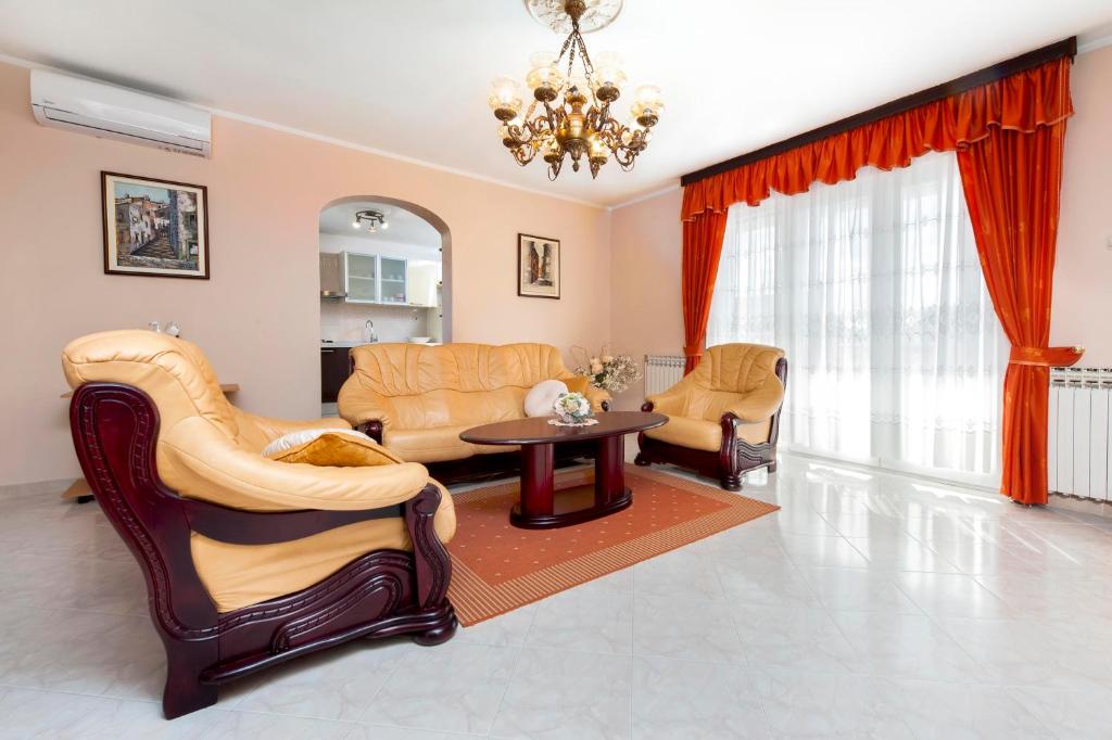 sala de estar con muebles y lámpara de araña en Apartments Divna, en Rovinj