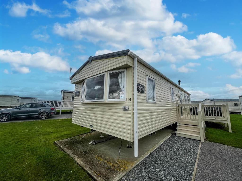 a tiny house is parked in a parking lot at Lovely 6 Berth Caravan With Wi-fi At Sand Le Mere In Yorkshire Ref 71091td in Tunstall