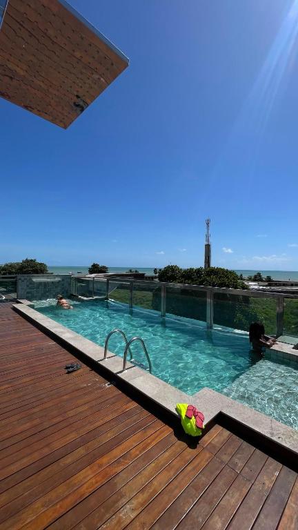 a swimming pool on top of a wooden deck at Israel flat tambau 106 in João Pessoa