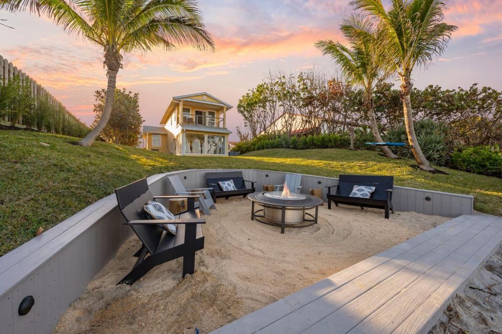 un patio con mesa y sillas en la arena en Casa Solana Resort Oceanfront Luxury 3 Master Suites & Backyard Oasis en Cocoa Beach