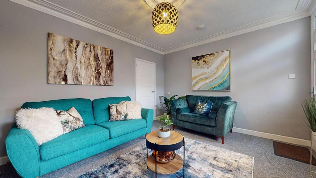 uma sala de estar com um sofá azul e duas cadeiras em Castle Boulevard Nottingham - 5 Beds Home - Long stays welcome for families, professionals & contractors em Nottingham