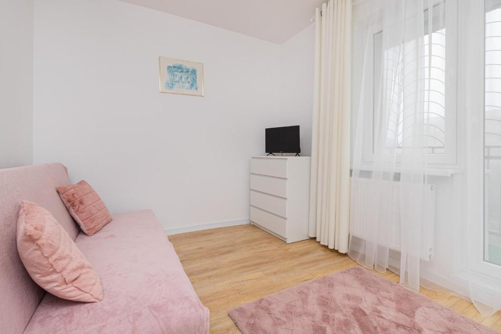 a white living room with a couch and a tv at 2 bedroom Apartment Zamiejska by Rent like home in Gdańsk