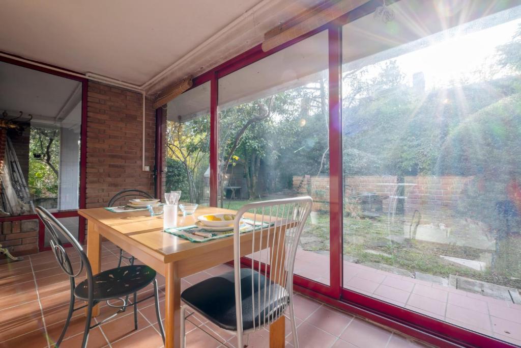 comedor con mesa y ventana grande en GetTheKey Villa Cedro, en San Lazzaro di Savena