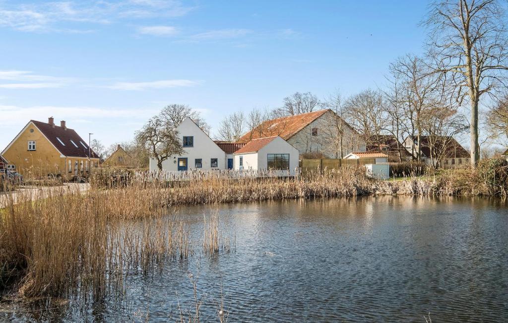 a house next to a river with buildings at 3 Bedroom Amazing Home In Sams in Kolby Kås