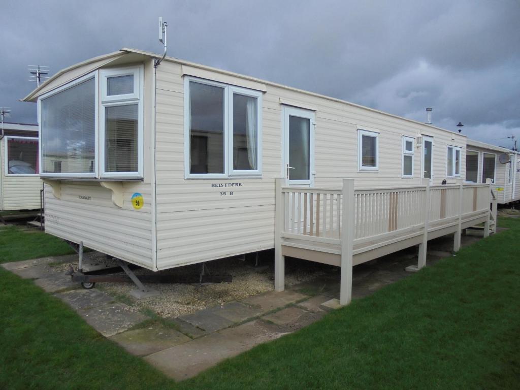 a white mobile home is parked in a yard at Seaview Belvedere 6 Berth Blow heated FREE WIFI in Ingoldmells