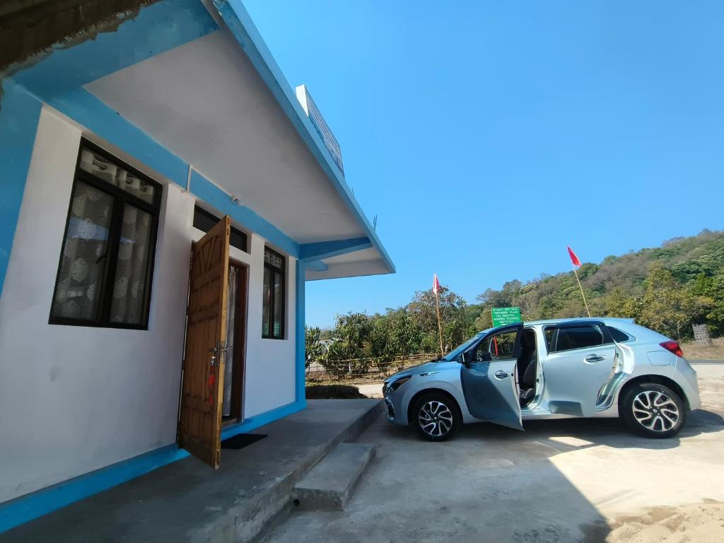 a car parked outside of a small building at EVELENA Guest House in Cherrapunji