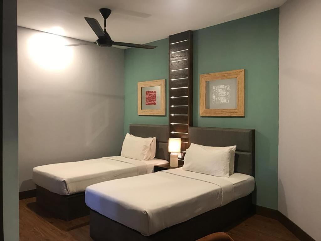 a room with two beds and a ceiling fan at Perhentian Island Resort in Perhentian Islands