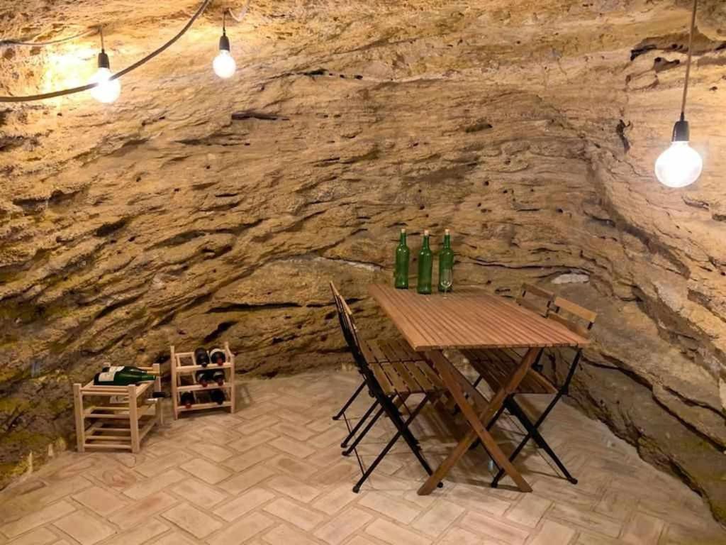- une table en bois dans une grotte avec un mur en pierre dans l'établissement AntiQua centro de Vejer con wifi Grupo AC Gestion, à Vejer de la Frontera