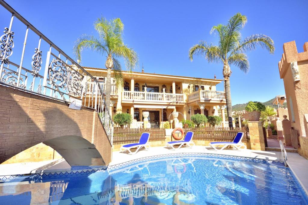 a house with a swimming pool in front of a house at Villa rural en Málaga con piscina y vistas al mar in Málaga