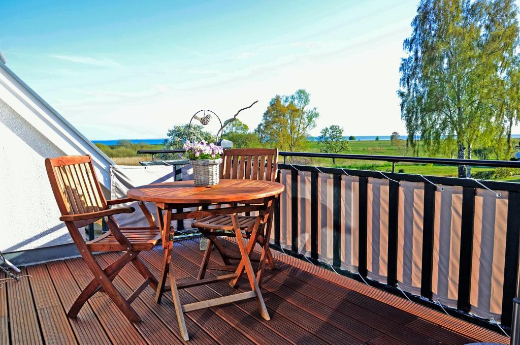 a wooden table and two chairs on a balcony at Inselliebe in Groß Zicker