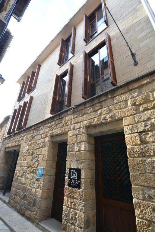 a brick building with windows and a sign on it at Ducay Rooms in Olite