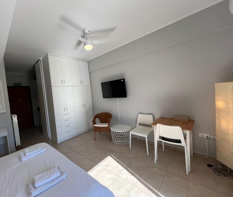 D1 Serenity Studio في أثينا: غرفة معيشة مع سرير وطاولة وكراسي