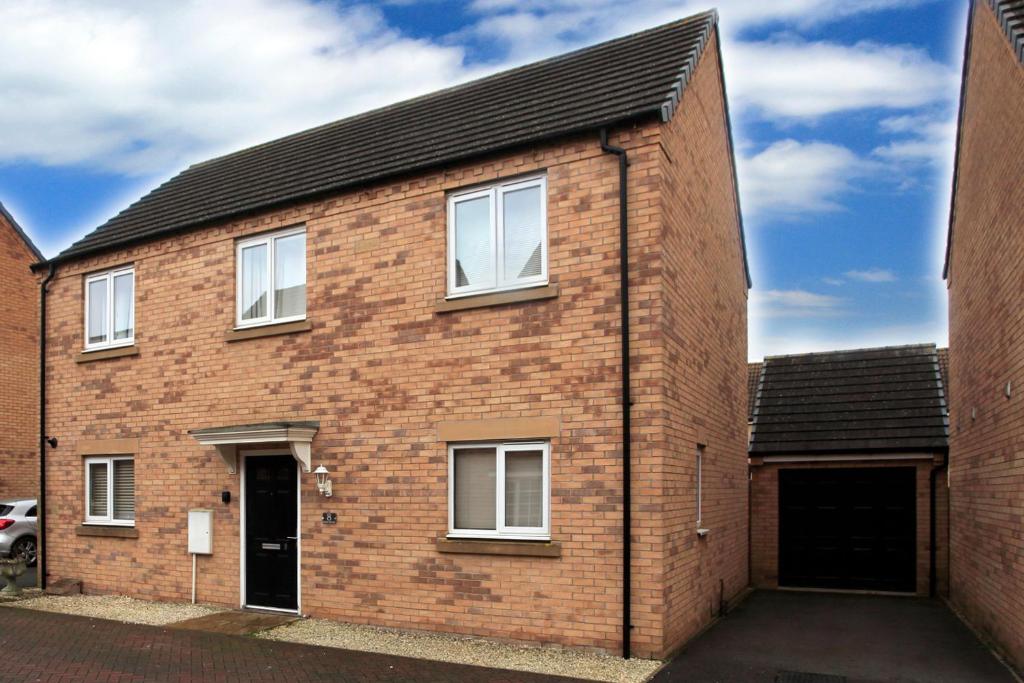 a red brick house with a black roof at Beautiful 5 Bed Detached House - Sleeps 9 in Peterborough