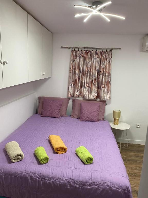 sypialnia z fioletowym łóżkiem z 2 poduszkami w obiekcie Studio Apartment in Split w Splicie