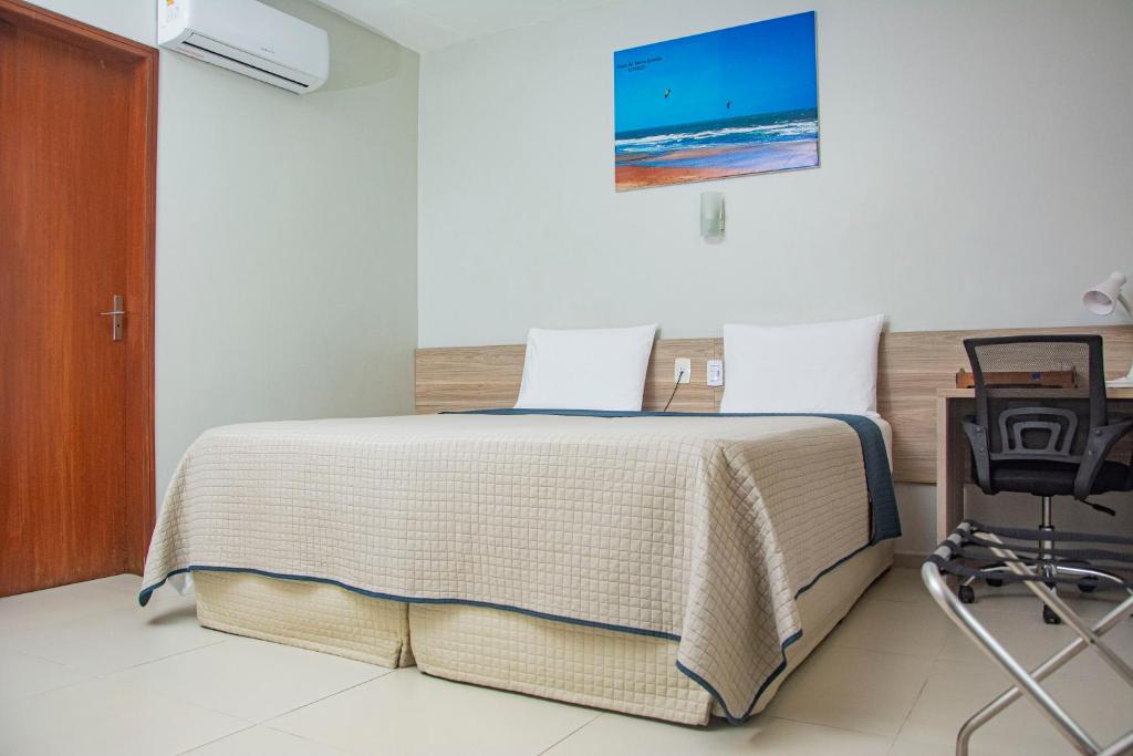 a bedroom with a bed with a laptop on it at Citi Executivo Hotel in Parnaíba