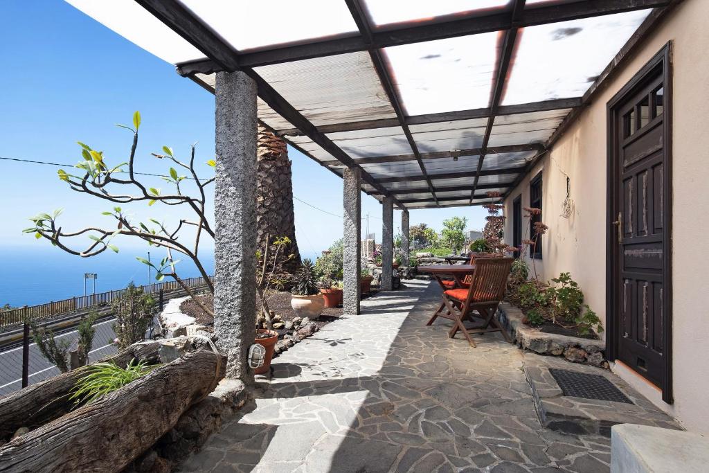 un patio al aire libre con pérgola y mesa en Casa La Podona- A, en Jedey